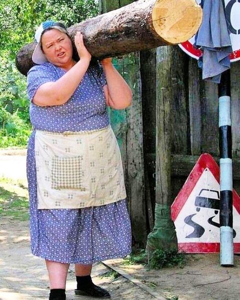 Женщина несет бревно