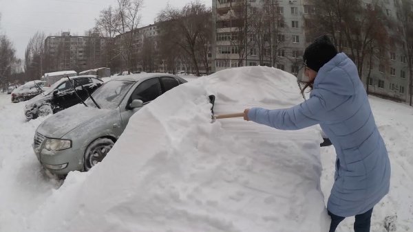 Откапывать машину из снега